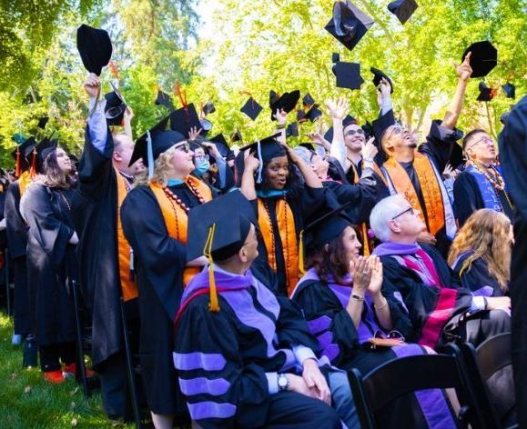 pacific graduates throwing caps in air